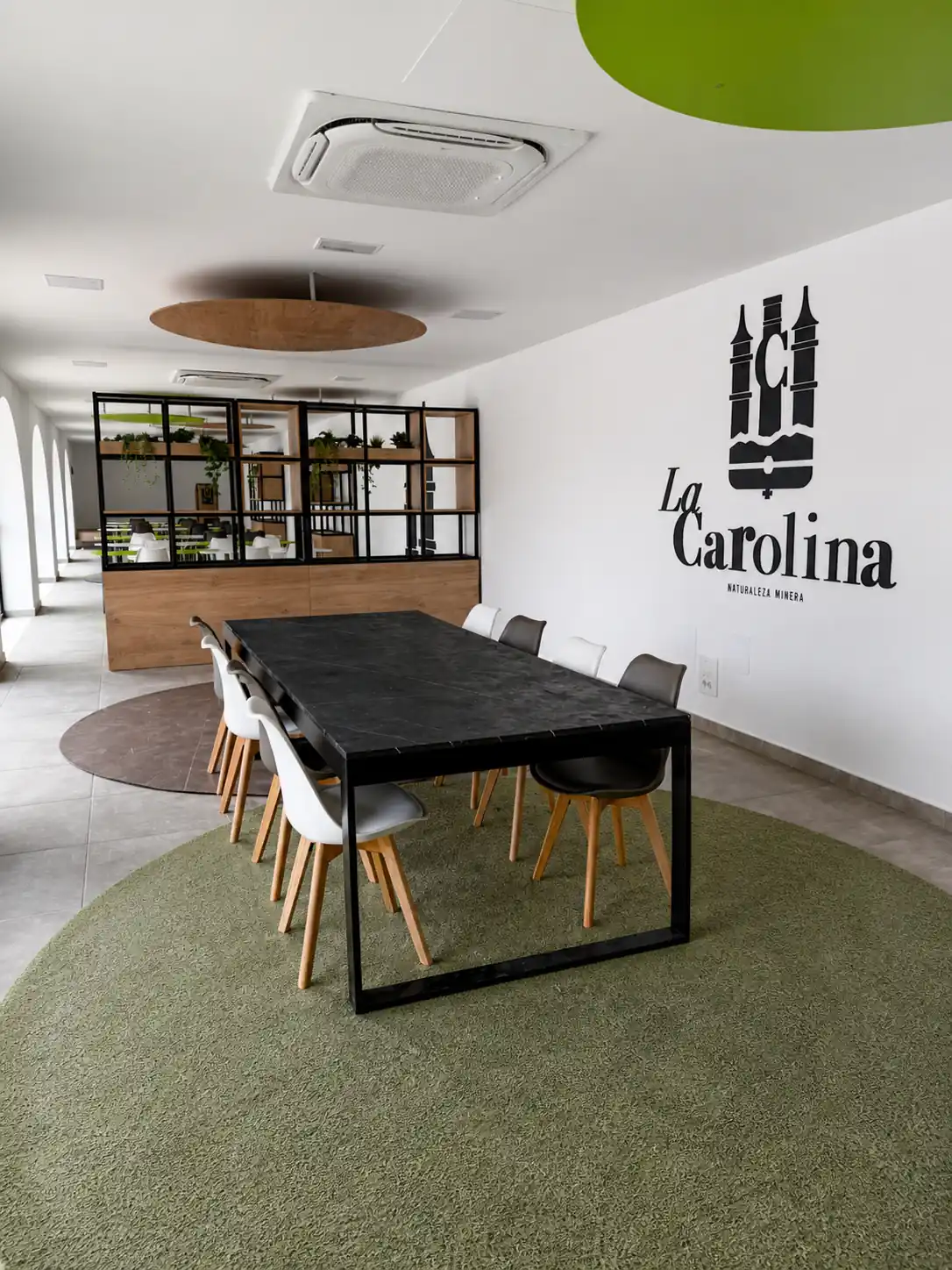 Oficina reforma La Carolina con mesa negra y moqueta verde y marron
