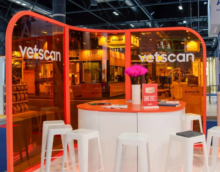Mesa con sillas en el espacio de metacrilato naranja en el stand de Zoetis